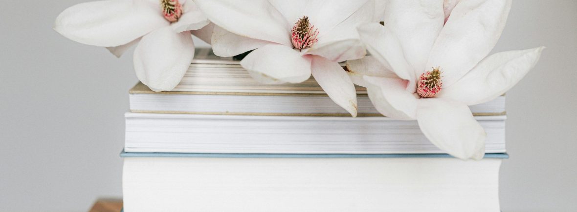 Editorial workspace with books and flowers